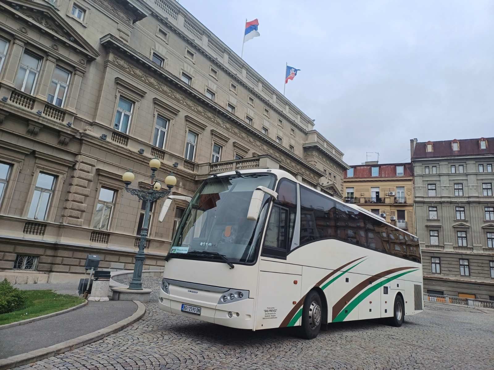 Beli autobus BAS PREVOZ ispred istorijske zgrade u gradu